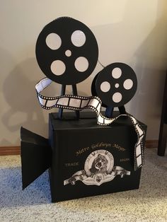 a box that has some film reels on top of it, sitting on the floor