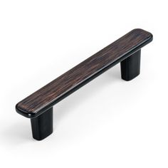 a wooden bench sitting on top of a white floor next to a black metal handle