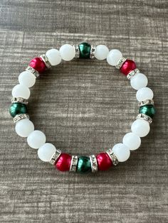 a white bracelet with red, green and silver beads