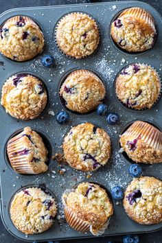 freshly baked blueberry muffins in a muffin tin ready to be eaten