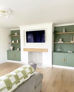 a living room filled with furniture and a flat screen tv mounted on the wall above a fireplace