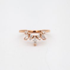 a gold ring with three pear shaped diamonds on it's side, set against a white background