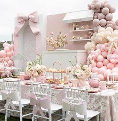 a table set up with pink and white balloons