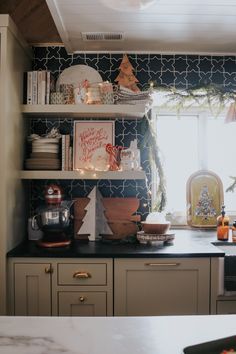 a kitchen with christmas decorations on the shelves