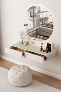 a round mirror sitting on top of a white shelf next to a stool and ottoman