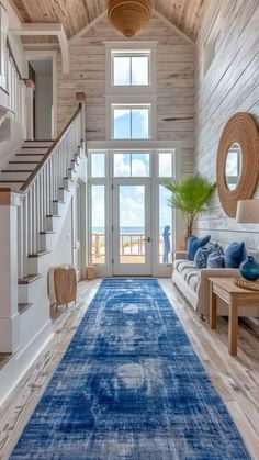 a large blue rug is in the middle of a room with stairs and a couch