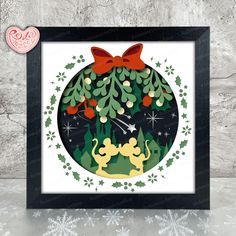 a christmas ornament with an image of two cats and holly wreaths on it