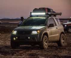 a pick up truck with its lights on in the mud