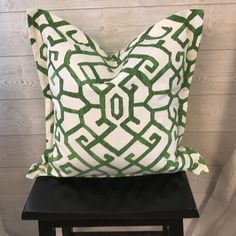 a green and white pillow sitting on top of a black stool