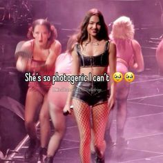 a woman in fishnet stockings walking on stage with other women behind her and texting she's so photogenic i can't