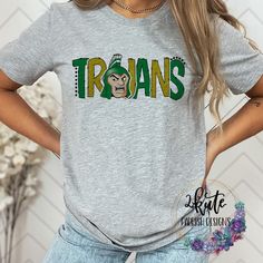 Treat yourself or anyone in your life to this awesome School pride tshirt. It's a Trojans thing.  Great for all occasions.  And great for supporting your trojans team.  Shirt is made of 95% polyester and 5% spandex. It's soft with great stretch.   To get the best wear from your shirt please  1. Wash with mild detergent  2. Do not use fabric softener  3. Do not use bleach 4. Tumble dry low.  Please enjoy your shirt as I know we have enjoyed all the ones we have made for ourselves!! Please note that every shirt is made to order and normal processing time takes us 5-7 business days to create a shirt and ship out an order; however we strive our very best to get it out sooner!  *some shirts are made by a process called sublimation printing. It is normal if you see some minor fading after your f School Spirit T-shirt For Game Day, Varsity T-shirt For College Football Season, Fan Apparel T-shirt With Mascot, Green Sports Season T-shirt For Fan Gear, Team-colored Mascot T-shirt For Sports Events, Sports Season Mascot T-shirt For Fans, Team Spirit Mascot T-shirt For Sports Events, Team Spirit T-shirt With Mascot For Sports Events, Mascot T-shirt For Sports Season Fan Merchandise