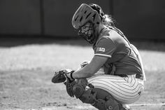 a baseball player squatting down on the field