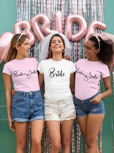 three young women standing next to each other in front of pink balloons and streamers