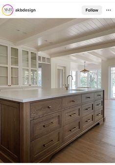 a large kitchen with an island in the middle and lots of cabinets on both sides