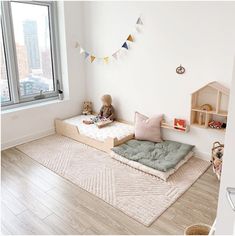 a child's room with wooden flooring and white walls, including a window