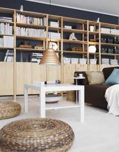 a living room filled with furniture and bookshelves next to a white coffee table