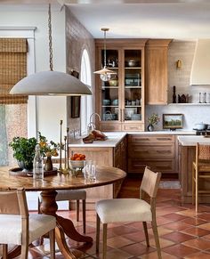 a kitchen filled with lots of wooden furniture and decor on top of tile flooring