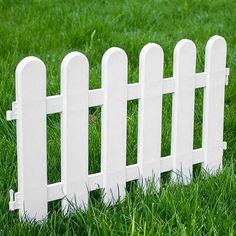 a white picket fence sitting in the grass