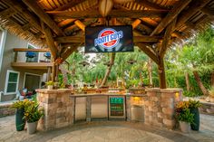 an outdoor bar with a giant pepsi sign on the wall and palm trees in the background