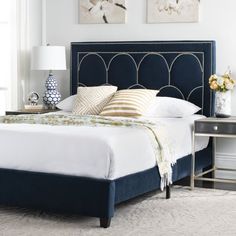 a bed with white sheets and blue headboard