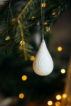 a white ornament hanging from a christmas tree