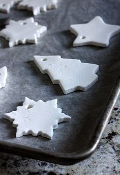 some white cookies are sitting on a cookie sheet and ready to be cut into shapes