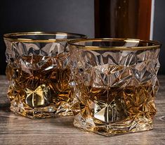 two glass tumblers sitting on top of a wooden table