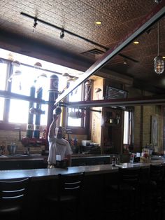 a man is standing at the bar with his arms in the air