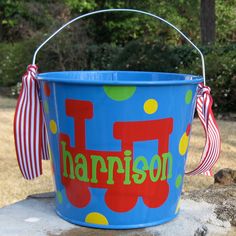 a blue bucket with a name on it and a bow hanging from the handle that says harrison