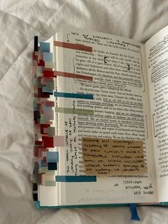 an open book with colorful strips of paper on it's cover and inside pages