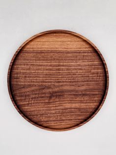 an empty wooden plate on a white surface