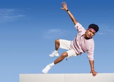 a young man is doing a trick on a skateboard against a blue sky background