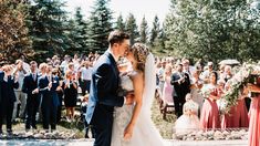 a bride and groom kissing in front of an outdoor wedding ceremony