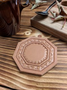 a close up of a piece of leather on a wooden table with other items in the background