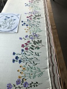 an embroidered table runner with flowers on it