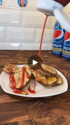 someone is pouring ketchup on some toasted bread and it's ready to be eaten