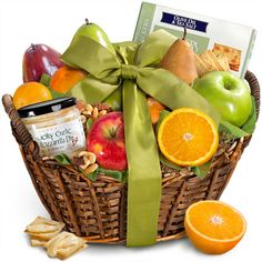 a basket filled with fruit and cheese next to sliced oranges, apples, and crackers