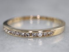 a yellow gold wedding band with five diamonds