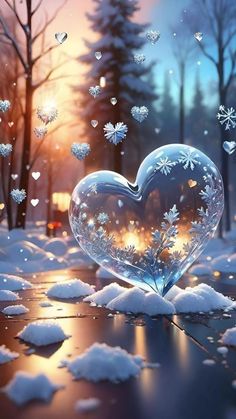 a heart shaped glass sitting in the middle of snow covered ground with trees and lights behind it