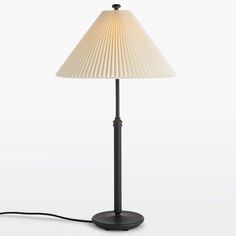 a lamp with a white shade on top of it and a cord attached to the base