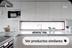 a kitchen with white cabinets and counter tops next to a window that has the words ver productos similares on it