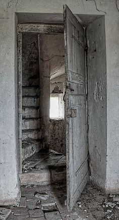 an open door leading to another room with bricks on the floor