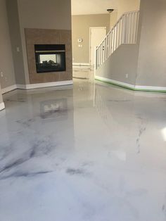 a white marble floor in a house with stairs leading up to the door and fireplace