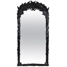 an ornate black mirror is shown against a white background with the reflection of it's leaves