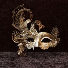 Phoenix Mask Papier-mâché mask, with metal insert. Venetian mask for wearing and decoration - Traditional and original Venetian mask made of papier-mâché, handmade and decorated with metal insert, gold leaf and glitter, enriched with Swarovski crystals. Size: All our masks are handmade papier-mâché masks made in Venice. Our decorators use traditional Venetian techniques such as stucco, acrylics, gold and silver leaf, macramé, trimmings, glitter and crequelé to offer you a wide range of original Phoenix Mask, Gold Masquerade Mask, Joker Mask, Paper Mache Mask, Venice Mask, Venetian Masquerade Masks, Dragon Mask, Ball Mask, Masked Ball