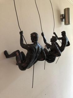 a statue hanging from the side of a wall with ropes attached to it's sides