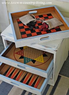 two wooden boxes are stacked on top of each other with decorative items in them,