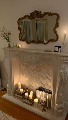 a living room with a fireplace, mirror and candles on the mantle in front of it