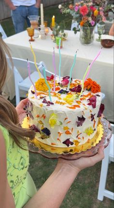 a woman holding a cake with candles on it