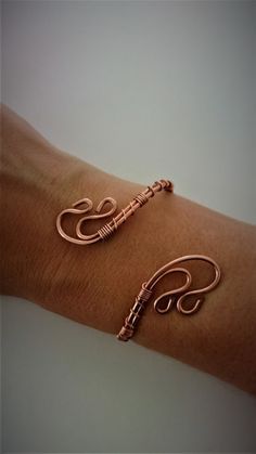 two copper bracelets on someone's arm